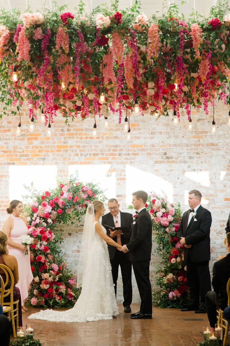 Ceremony beneath a hanging floral installation at Bakery 105