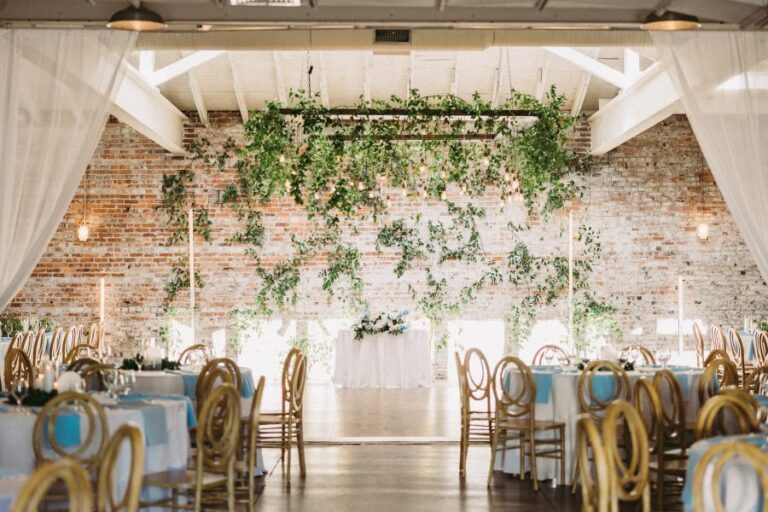 Hall set for a reception with hanging greenery at Bakery 105