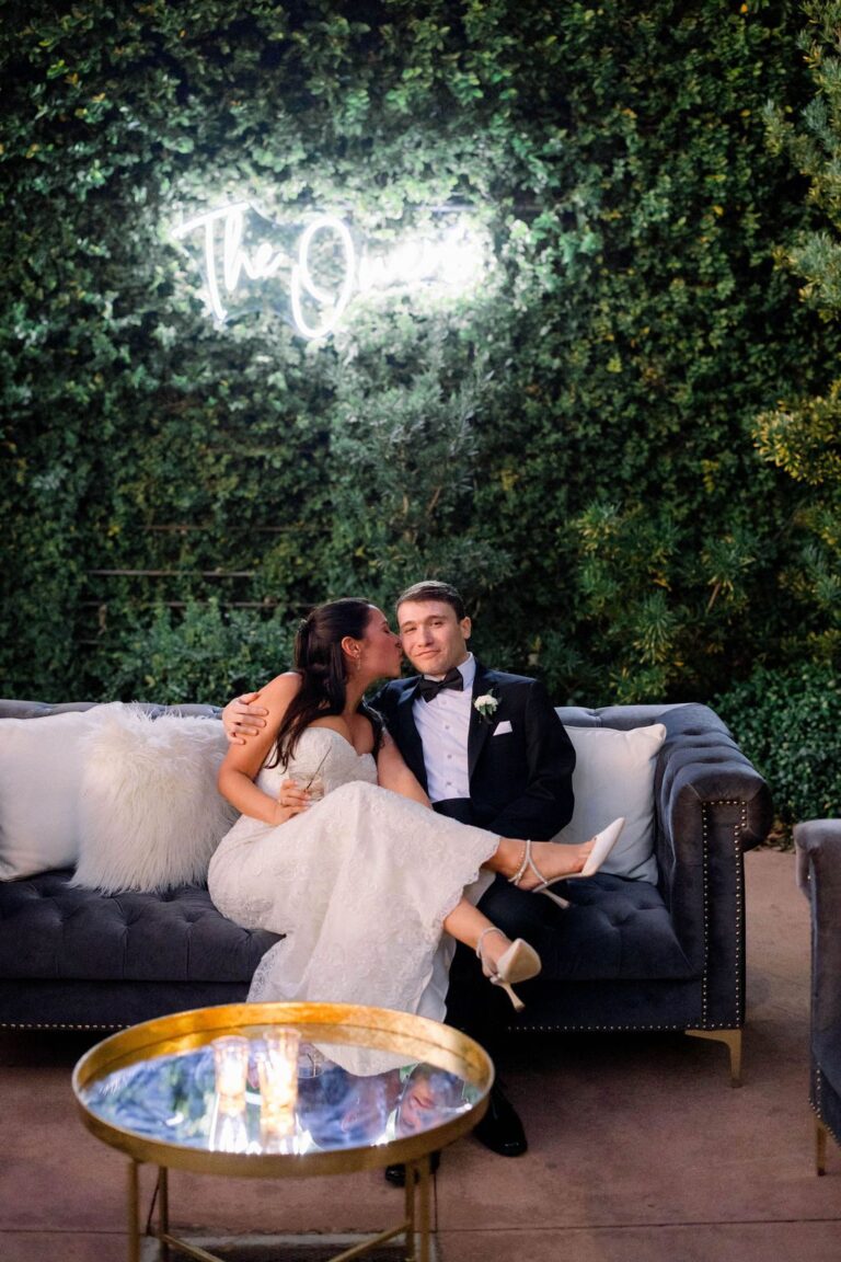 Couple on a lounge sofa beneath a neon sign at Bakery 105