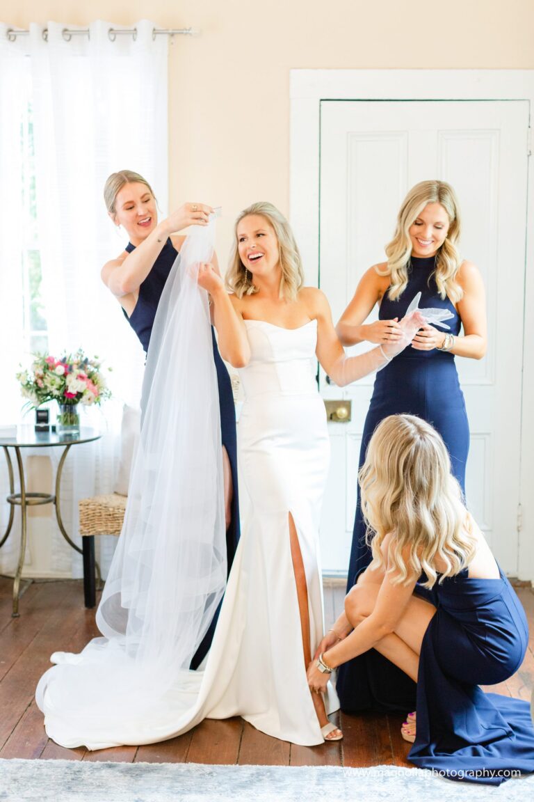 Bridesmaids helping the bride with her veil at The Cottage