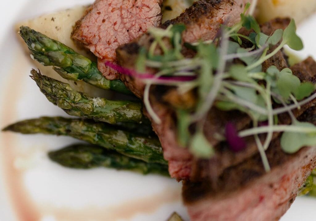 Sliced steak with asparagus and roasted potatoes by 128 South Catering